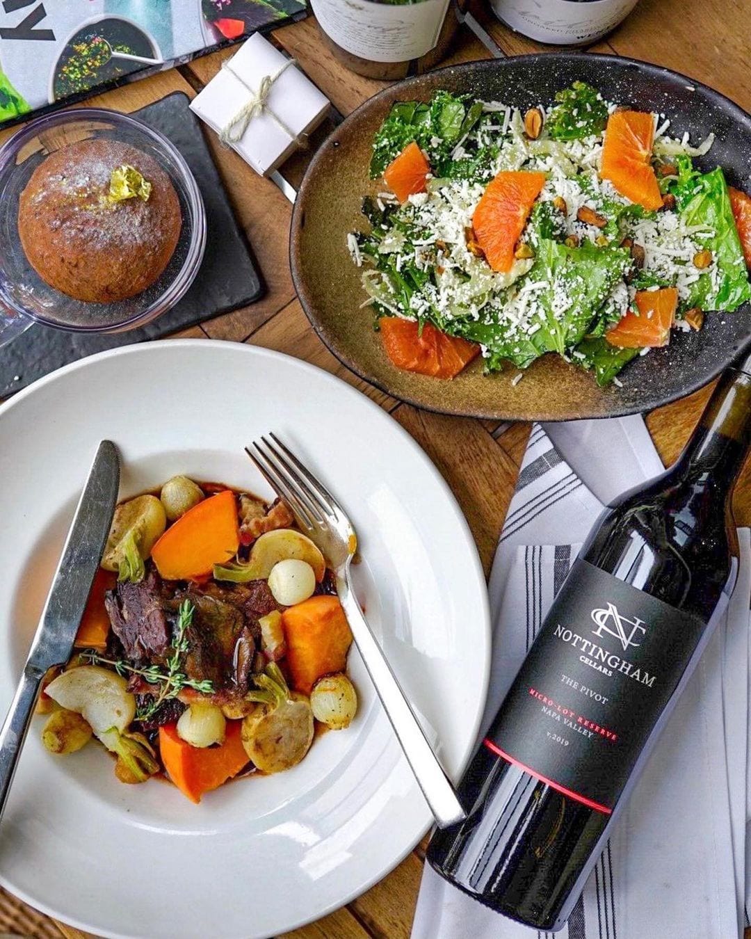 plate of food with salad and bottle of wine