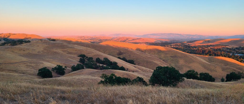 Sunrise over golden hills.