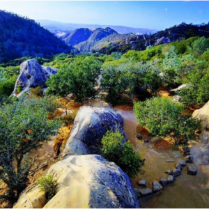 Odd rock formations are scattered with hills and valleys behind them at Mt. Diablo State Park